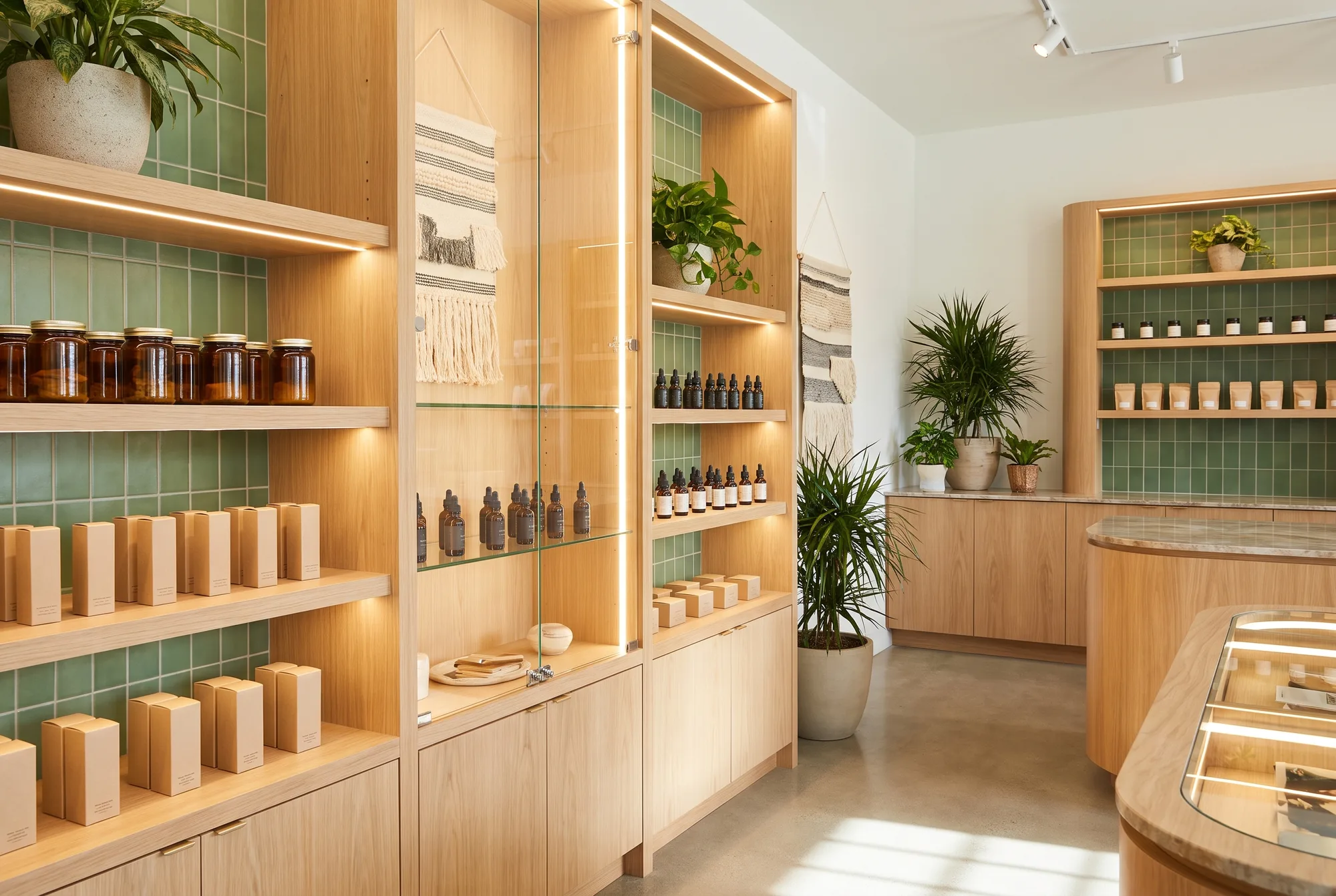 Interior of a hemp dispensary with neatly stocked glass display shelves of jars and wellness products